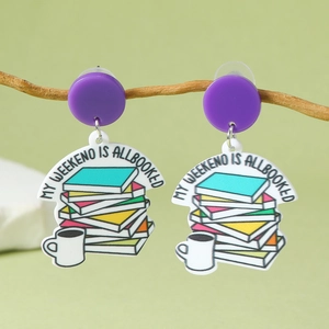 Détail de boucles d'oreilles créatives en acrylique avec motif de livres et texte