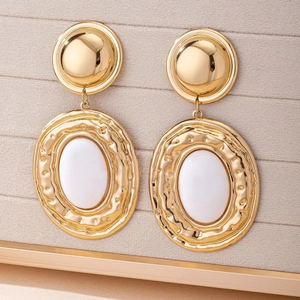 Retro bohemian gold earrings with hammered texture and white resin oval pendant