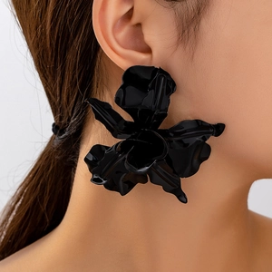 Nahaufnahme großer schwarzer 3D-Blumenohrring mit glänzenden Blütenblättern am Modell