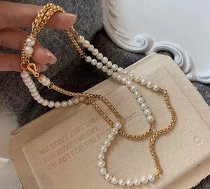 Gedetailleerd overzicht van de lange parelketting met gouden schakels en vintage sluiting