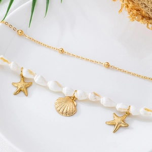 Vue détaillée de la chaîne de taille bohème en coquillages avec étoiles de mer dorées