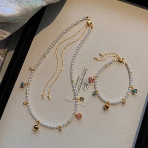 Detailed view of handmade pearl necklace set with colorful teardrop gemstone charms