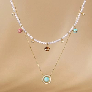 Detail of 18K gold-plated double-layer necklace with pearls and planet charms