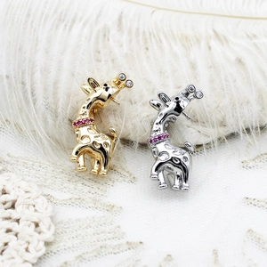 Dettaglio di spille a forma di giraffa bicolore in oro e argento con cristalli lucidi