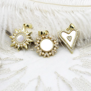 Golden sun, heart, and snowflake charms with white shell, pearls, and zircons