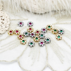 Détail de breloques en forme de fleurs plaquées or 18k avec zircons colorés et perles