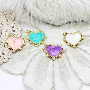 Detailed view of colorful heart charms with marble enamel finish and 18K gold plated edge