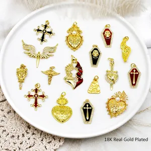 Detalle de dijes góticos bañados en oro de 18K con cruces y alas de ángel talladas