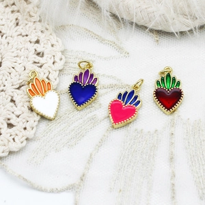 Detail of colorful enamel sacred heart pendants with gold plating for jewelry making