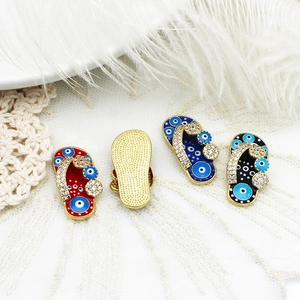 Detailed macro view of evil eye slipper charms with colorful enamel and zircon accents