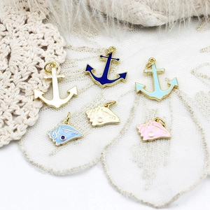 Detail of colorful enamel anchor and conch shell charms for DIY jewelry making