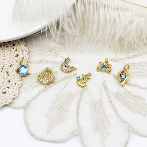 Golden ocean animal charms with blue zircons featuring turtles and shells on lace