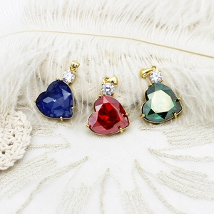 Close-up of heart-shaped 18K gold-plated pendants with blue, red, and green gems
