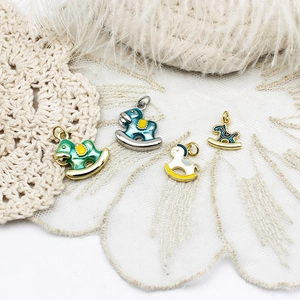 18K gold plated copper rocking horse pendants in four colors on white lace fabric