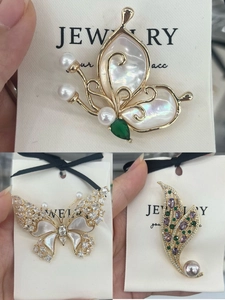 Detailed macro of butterfly brooches with natural mother of pearl and zircon inlay