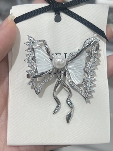 Detail of luxury butterfly brooch with natural mother-of-pearl wings and zirconia inlay