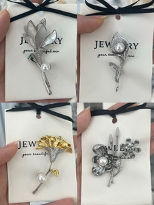 Detailed views of lily and tulip brooches with copper zircon and pearl inlays