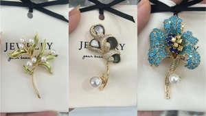 Macro detail of high-quality lily and lotus brooches with pearls and blue crystals
