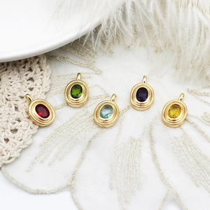 Cinq pendentifs ovales en pierres colorées avec monture plaquée or 18 carats sur dentelle