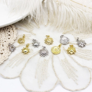 Pendentifs soleil et boussole or et argent pour bijoux DIY sur fond de dentelle