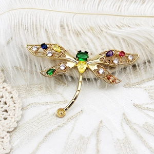 Détail de la broche libellule avec cristaux colorés et ailes en métal ajourées