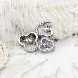 Detailed view of silver clover brooch setting with micro-pave zircons and bead mounts