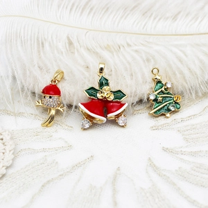 Detailed view of Christmas charms including a bird, red bell, and zircon Xmas tree