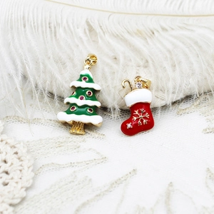 Detailed macro of gold-plated Christmas tree and stocking charms with sparkling zircons