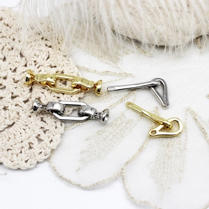 Detail view of 18k gold and silver plated lobster clasps on a white lace background