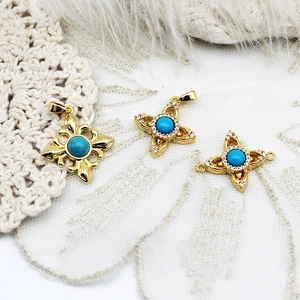 Detailed macro view of vintage turquoise fleur-de-lis and star-shaped golden charms