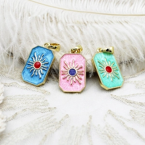 Detailed macro of gold-plated tarot pendants with sun patterns in three vibrant colors