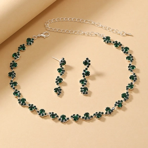 Close-up of deep green crystal necklace and matching drop earrings with silver metal