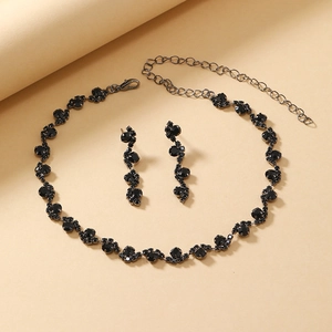 Macro shot of black rhinestone necklace and earrings set with gothic dark gunmetal finish