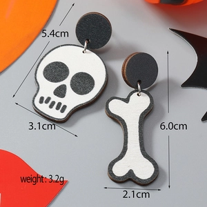 Dettaglio degli orecchini asimmetrici di Halloween in legno con teschio e ossa lunghe
