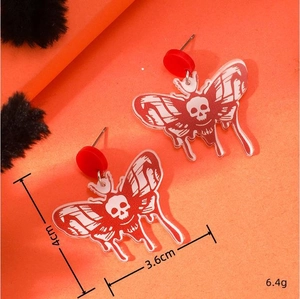 Macro view showing dimensions and gothic skull moth design on red acrylic earrings