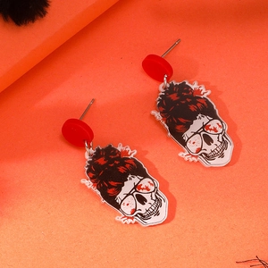 Macro shot of Halloween skull earrings featuring messy bun and red tinted sunglasses