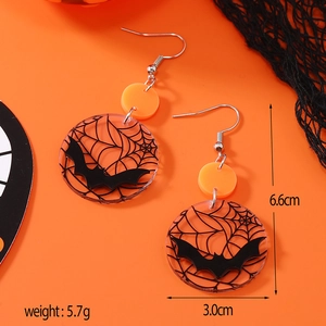 Detalle de pendientes de Halloween con siluetas naranjas y motivos de telarañas negras