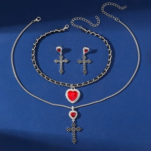 Dettaglio del set punk gotico con collana cuore croce e orecchini con pietre rosse