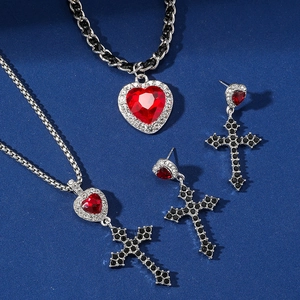 Dettaglio macro del set di gioielli gotici con cuori rossi e croci di cristallo nero
