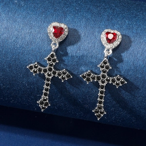 Orecchini gotici con cuori rossi e pendenti a croce nera su velluto blu scuro