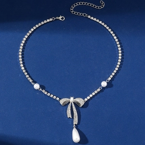 Elegante Halskette mit Strass-Schleife und weißen Perlenimitaten an einer verstellbaren Kette