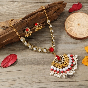 Luxuriöses indisches Schmuckset mit goldenen Quasten, roten Steinen und Perlen