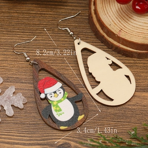 Detalle de pendientes de madera navideños con dimensiones de pingüino y Papá Noel