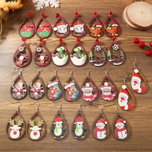 Detalle macro de pendientes navideños de madera con motivos de Papá Noel y renos
