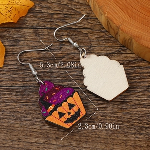 Macro view of Halloween cupcake earrings with wizard hat and pumpkin print details