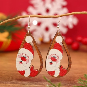 Pendientes de madera con forma de gota de Papá Noel sobre un fondo decorativo de Navidad