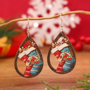 Pendientes de madera navideños con motivos festivos colgados de ramas rústicas