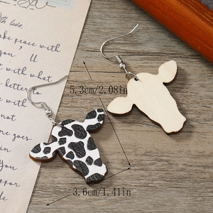 Détail de boucles d'oreilles en bois à imprimé vache montrant texture et mesures