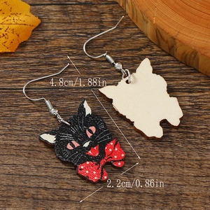Detailed macro view showing the size dimensions of the black cat earrings on a wooden background
