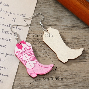 Détail de boucles d'oreilles bottes de cow-boy roses avec imprimé flamme et mesure de 6,2 cm
